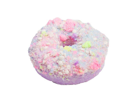 a donut with pink and pink sprinkles sitting on a table 